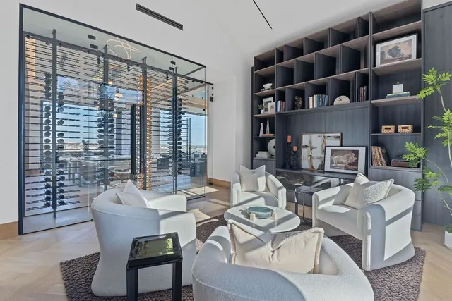 a living room with furniture a bookshelf and a large window