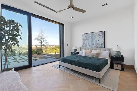 a living room with a bed furniture next to a large window