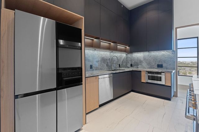 a kitchen with stainless steel appliances a refrigerator and a stove