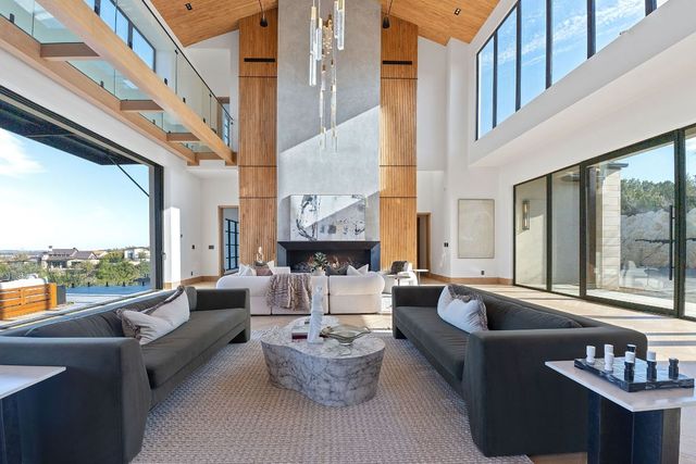 a living room with fireplace furniture and a large window
