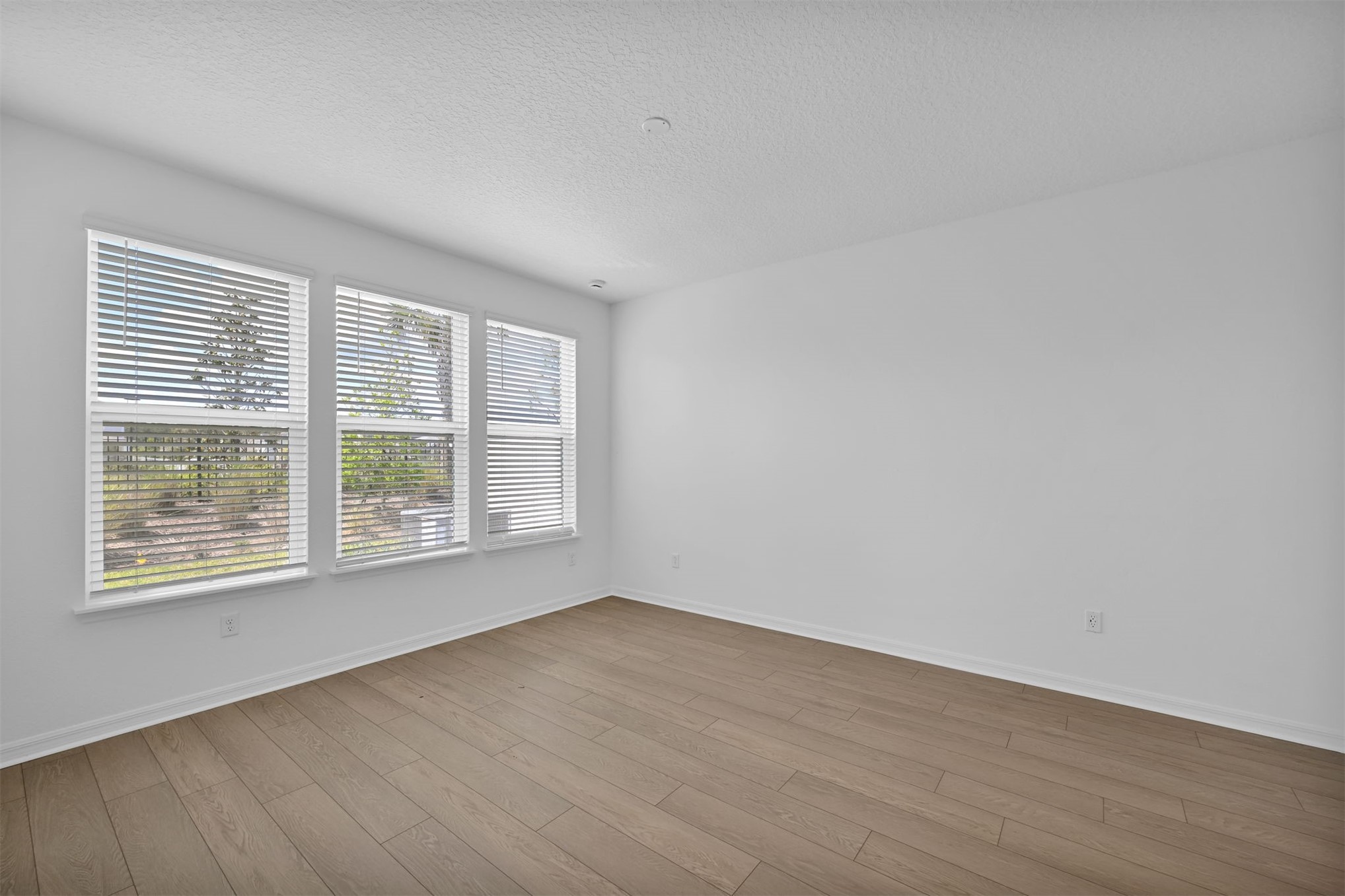 328 Ecliptic Loop Yulee, FL 32097 - Photo 16 of 41 a view of an empty room with wooden floor and a window
