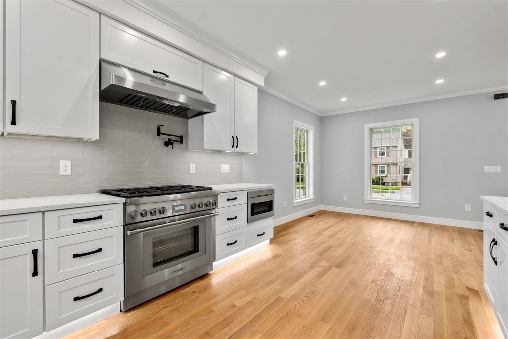 121 Oliver Road Belmont, MA 02478 - Photo 11 of 34 a kitchen with stainless steel appliances a stove and a wooden floor