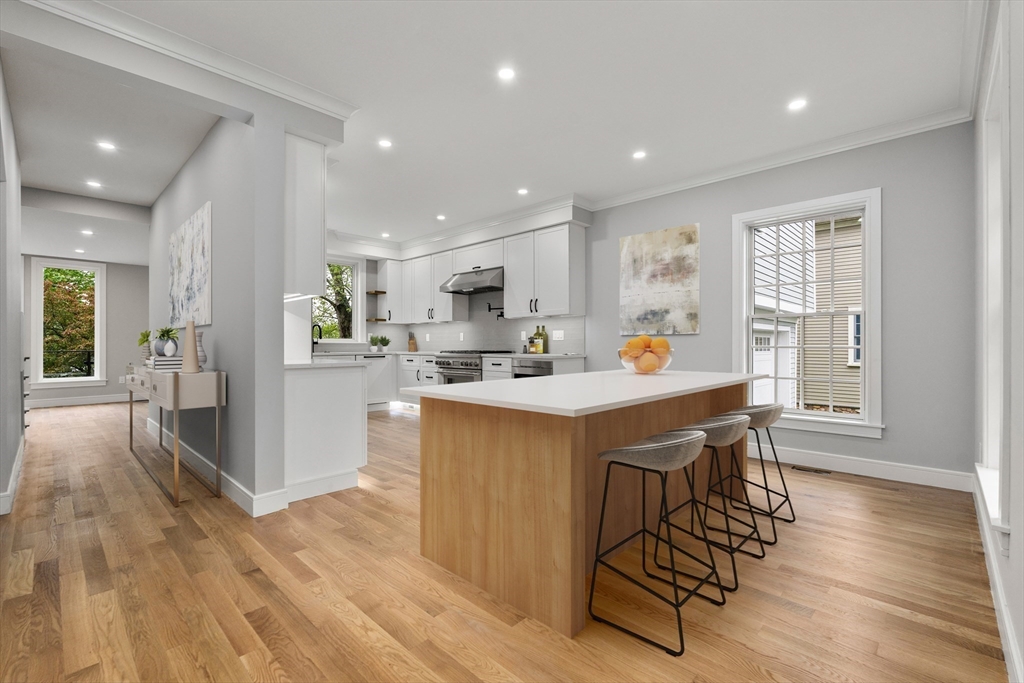 121 Oliver Road Belmont, MA 02478 - Photo 6 of 34 a kitchen with a table chairs refrigerator and wooden cabinets