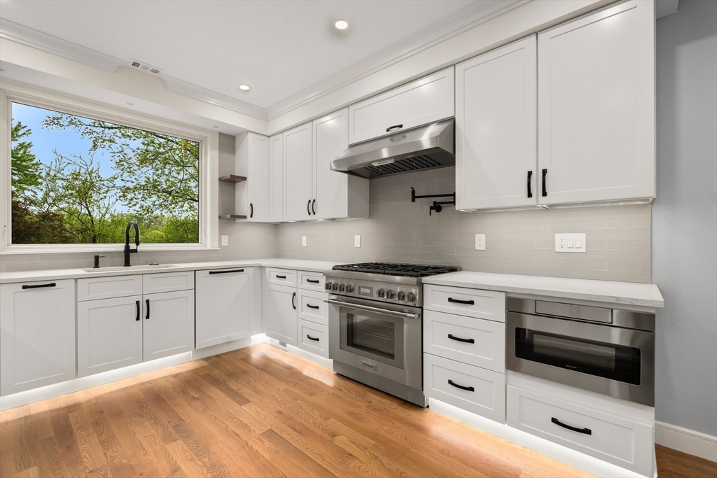121 Oliver Road Belmont, MA 02478 - Photo 8 of 34 a kitchen with stainless steel appliances white cabinets and a wooden floor