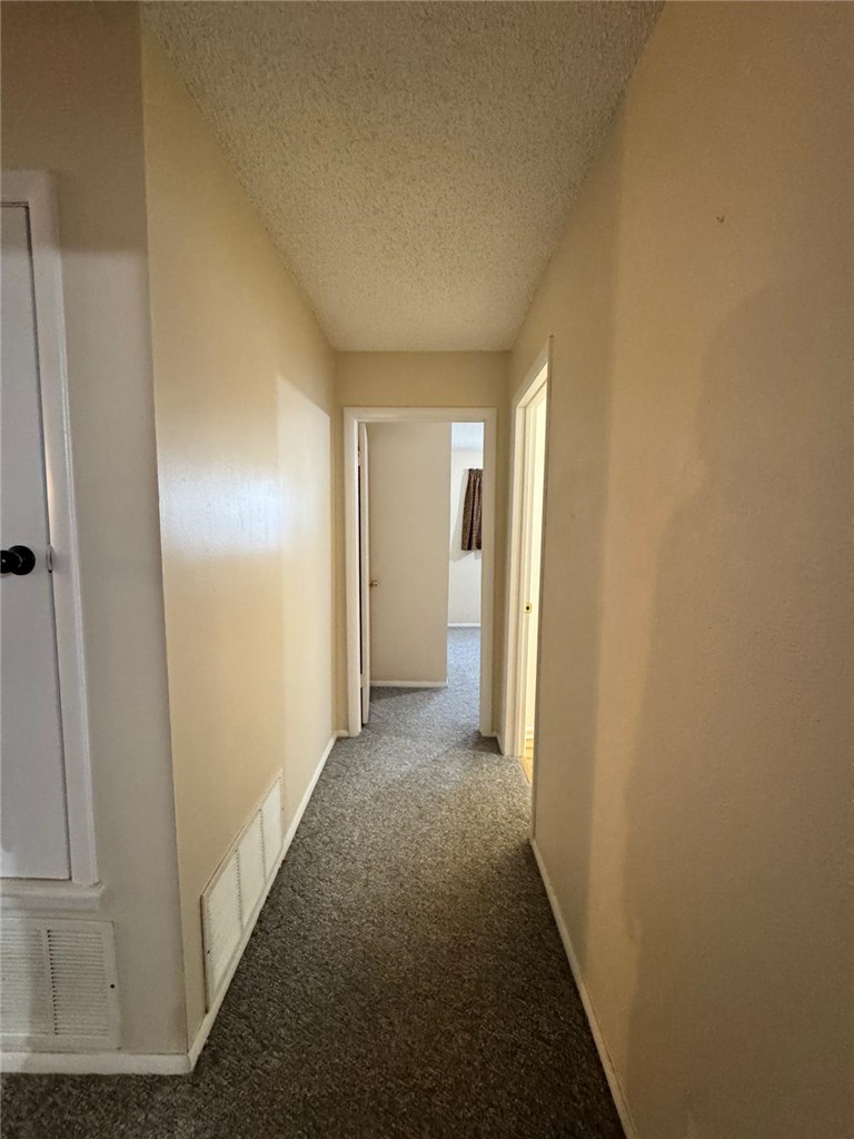 915 Maple Shade Road Alma, AR 72921 - Photo 12 of 18 Corridor featuring carpet flooring and a textured ceiling