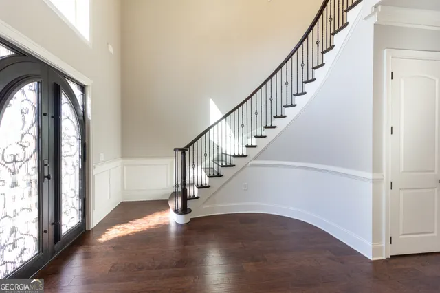 a view of a room with wooden floor and a ceiling fan