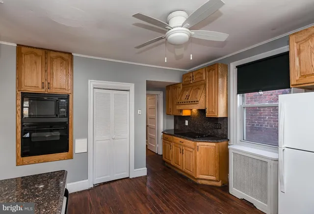 a kitchen with stainless steel appliances granite countertop a refrigerator and a stove top oven