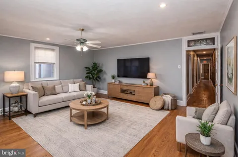 a living room with furniture a flat screen tv and a window