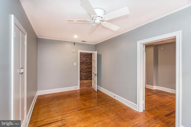 an empty room with closet and a ceiling fan