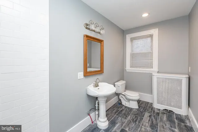 a bathroom with a toilet a sink and mirror