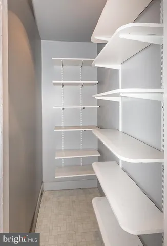a view of walk in closet with empty racks