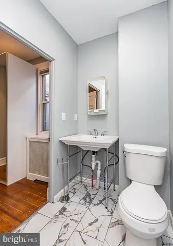a bathroom with a toilet a sink and a mirror