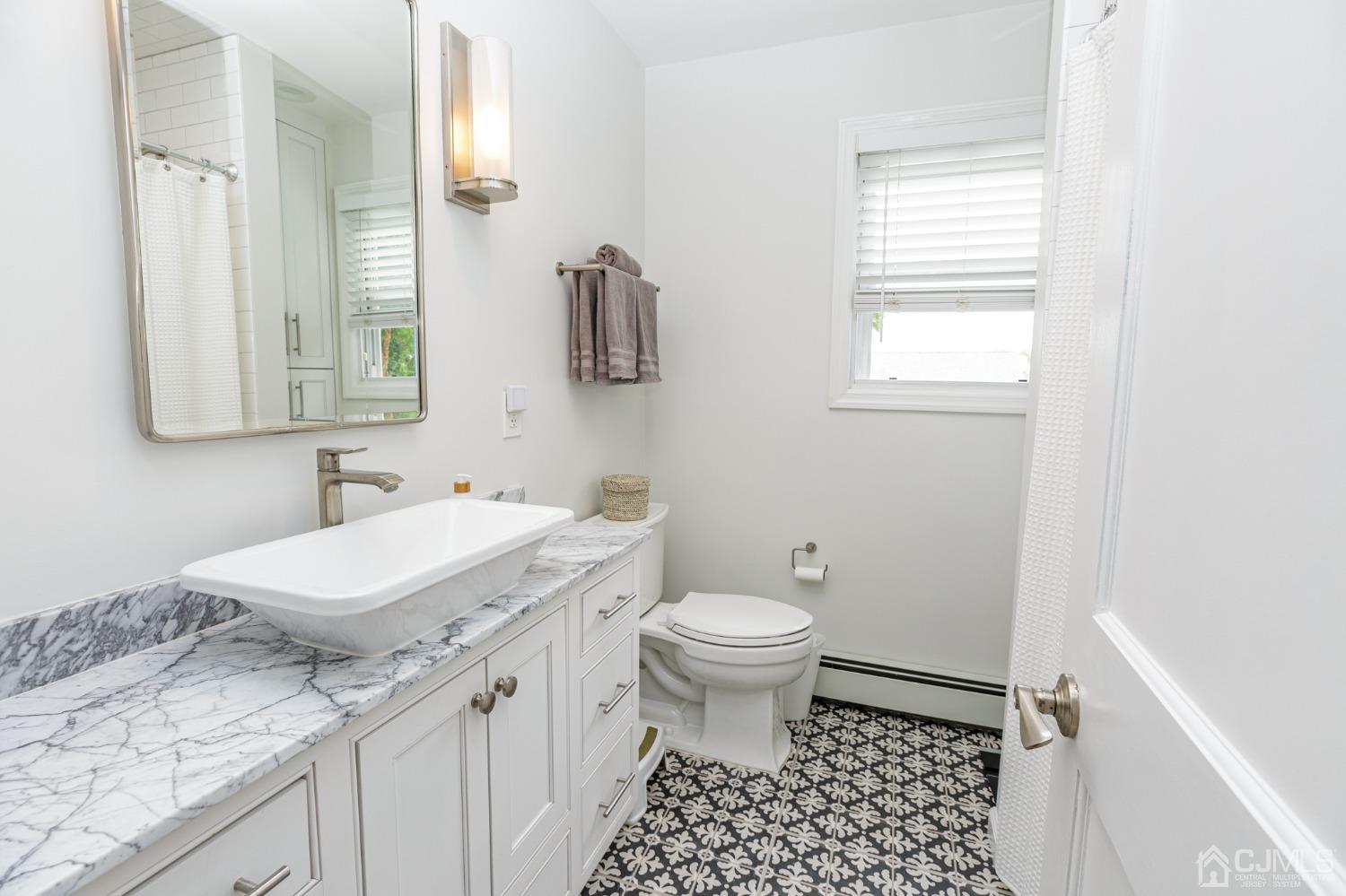 215 Hillside Road Elizabeth, NJ 07208 - Photo 18 of 37 a bathroom with a sink a toilet a mirror and window