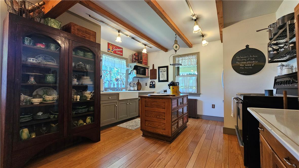 585 Buttermilk Road Hellertown, PA 18055 - Photo 10 of 82 A well-lit kitchen features hardwood flooring and beamed ceilings, creating a rustic yet inviting atmosphere.