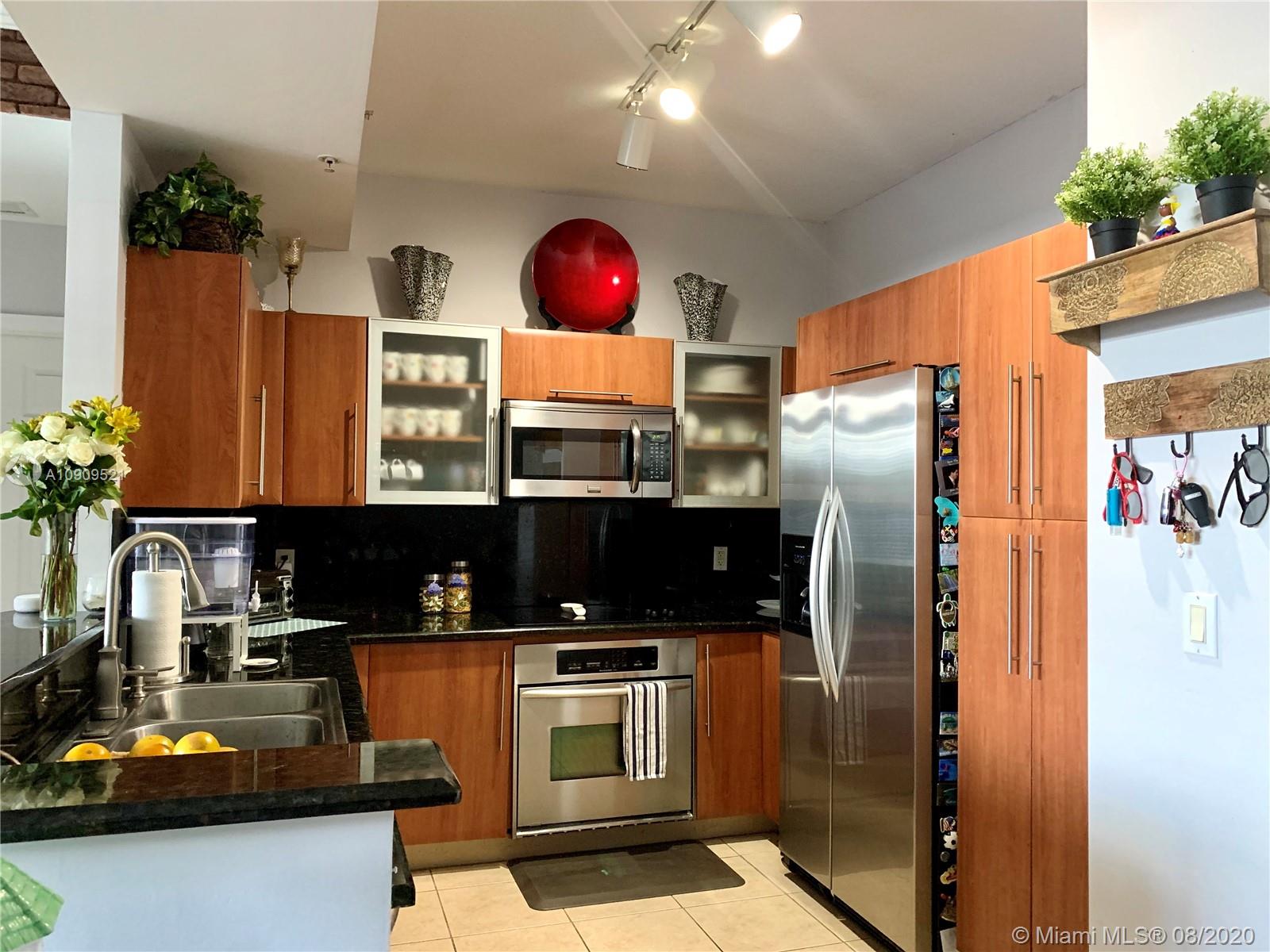 a kitchen with stainless steel appliances granite countertop a refrigerator and a stove