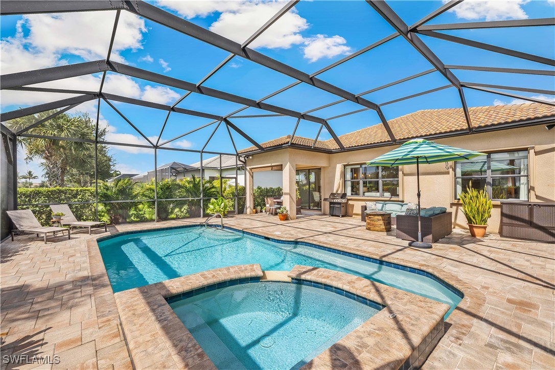12894 Epping Way Fort Myers, FL 33913 - Photo 33 of 49 a view of a backyard with swimming pool table and chairs under an umbrella