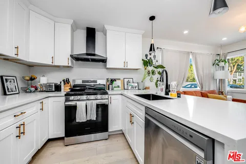 a kitchen with white cabinets and white appliances