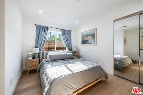 a bed sitting in a bedroom next to a window