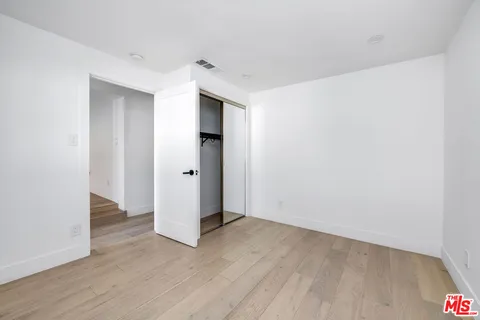 an empty room with wooden floor and white doors
