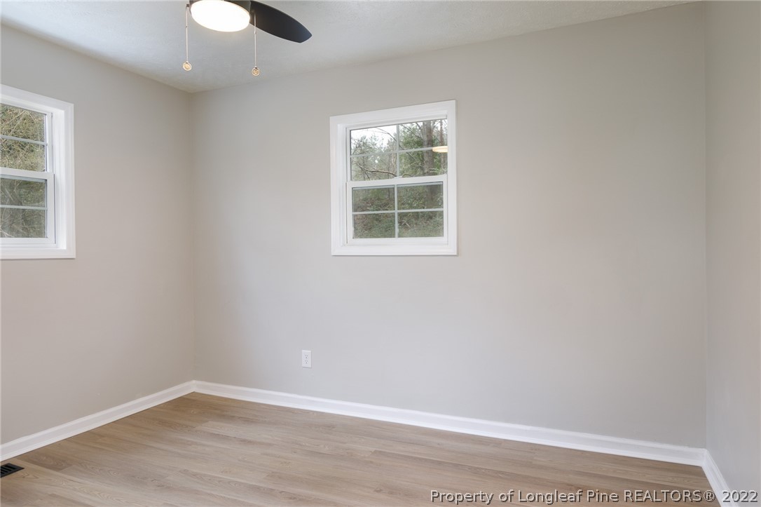 595 Midway Road Aberdeen, NC 28315 - Photo 17 of 22 an empty room with wooden floor and windows