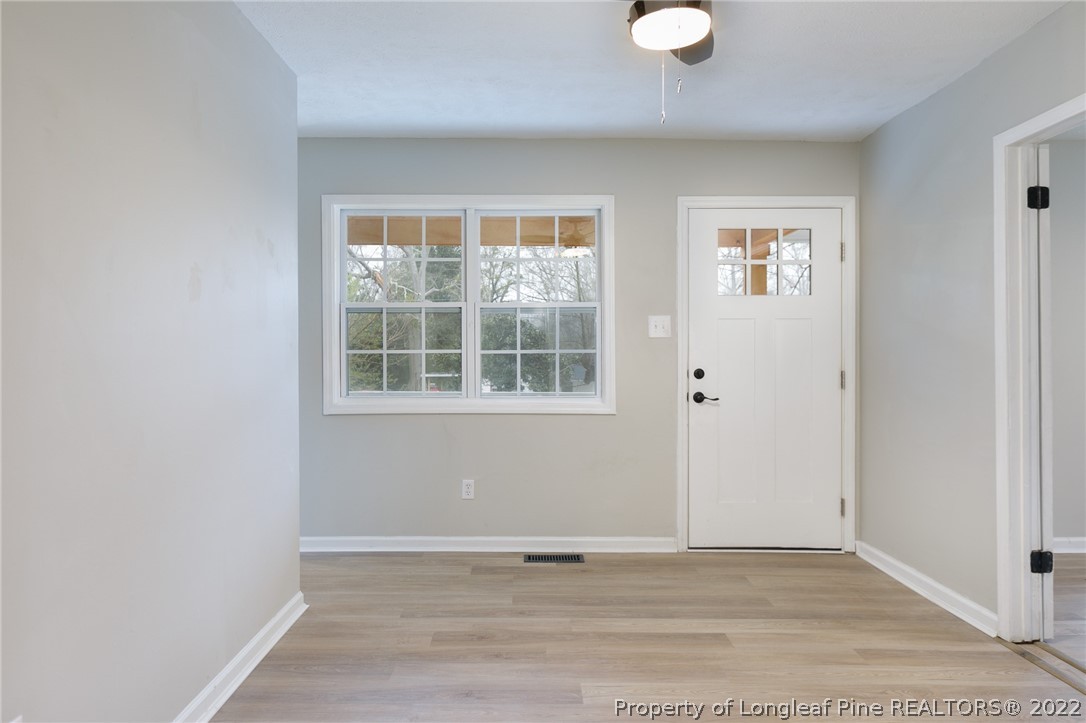 595 Midway Road Aberdeen, NC 28315 - Photo 5 of 22 an empty room with wooden floor and windows