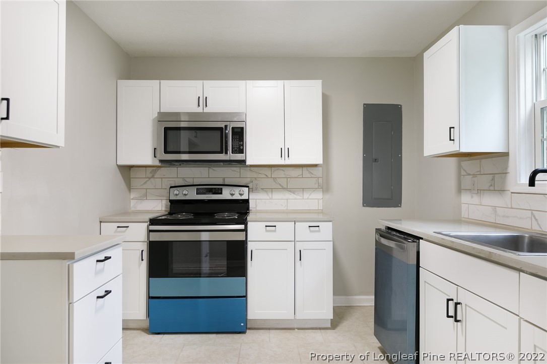 595 Midway Road Aberdeen, NC 28315 - Photo 8 of 22 a kitchen with granite countertop white cabinets and stainless steel appliances