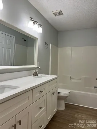 a bathroom with a granite countertop sink a toilet and a bathtub