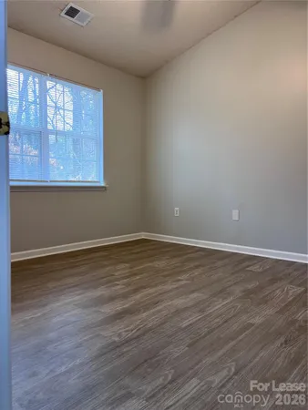 a view of a room with wooden floor and window