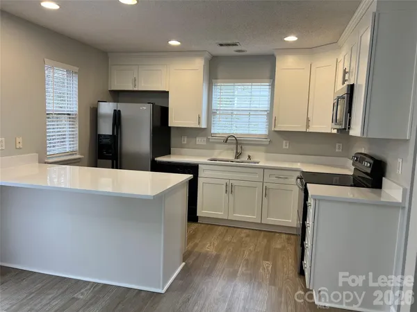 a kitchen with a sink a refrigerator and cabinets
