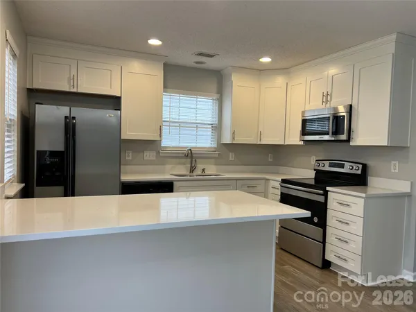 a kitchen with stainless steel appliances a refrigerator sink and microwave