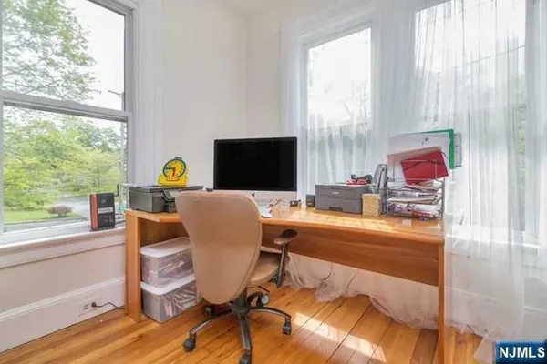 a view of a workspace with furniture and a window