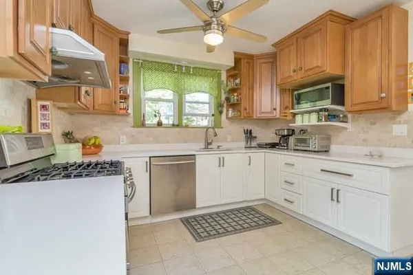 a kitchen with stainless steel appliances granite countertop a sink stove and cabinets