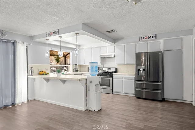 a kitchen with a refrigerator and white cabinets