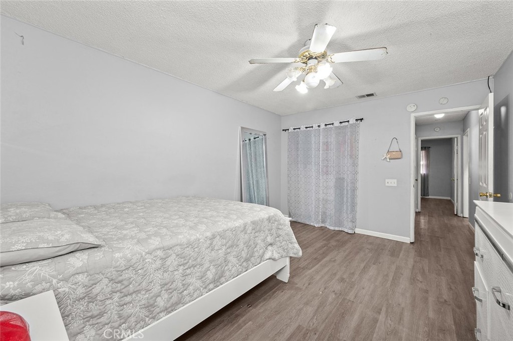 15811 Hercules Street Hesperia, CA 92345 - Photo 23 of 43 a spacious bedroom with a bed and a chandelier