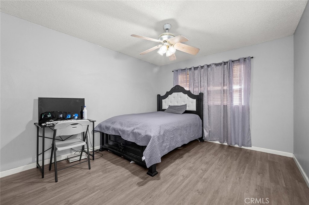15811 Hercules Street Hesperia, CA 92345 - Photo 25 of 43 a bedroom with a bed and wooden floor