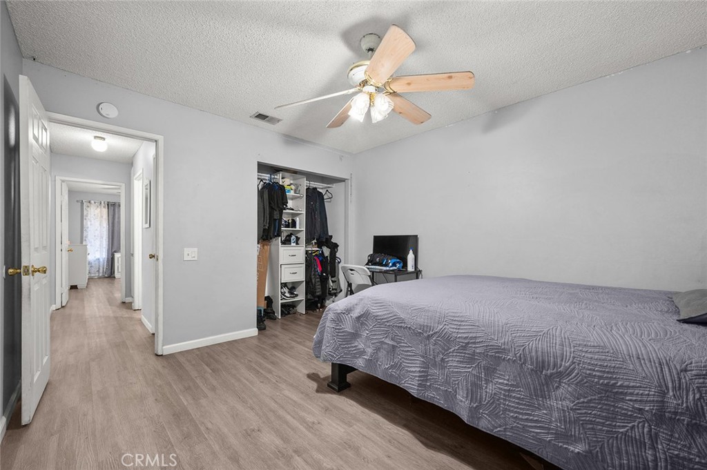 15811 Hercules Street Hesperia, CA 92345 - Photo 26 of 43 a bedroom with a bed and a chandelier