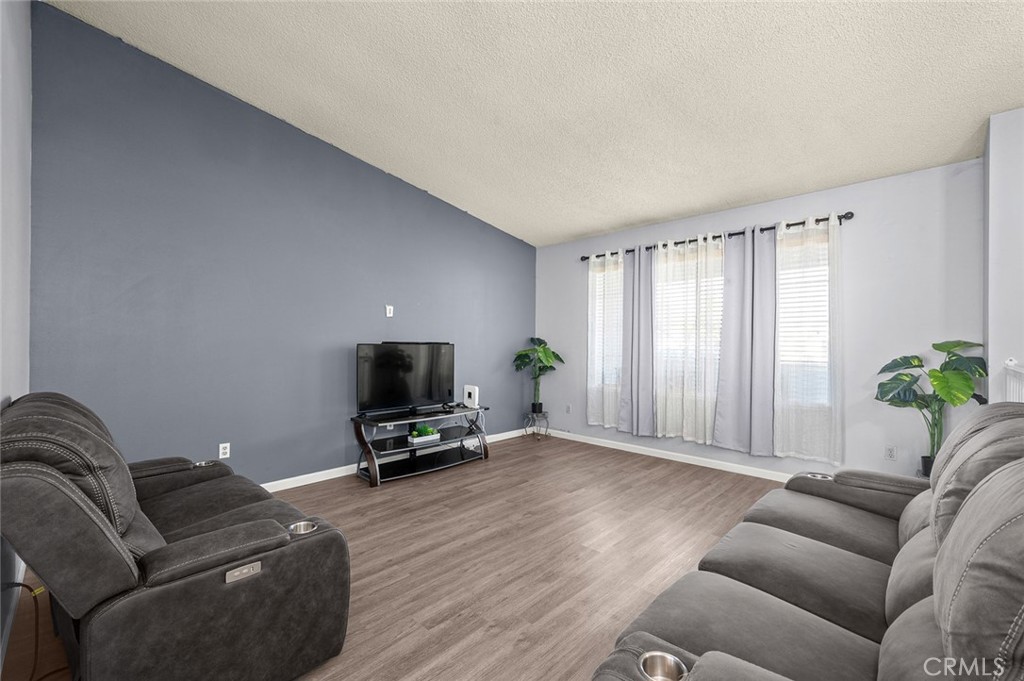 15811 Hercules Street Hesperia, CA 92345 - Photo 10 of 43 a living room with furniture a window and a flat screen tv
