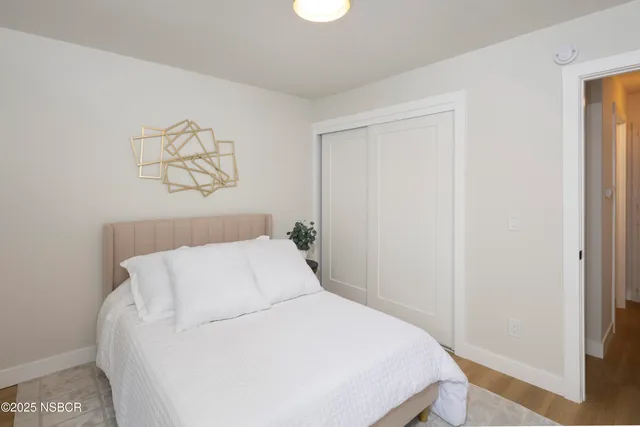 a bedroom with a bed and painting on the wall