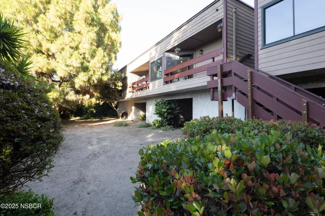 a view of a house with a yard and potted plants