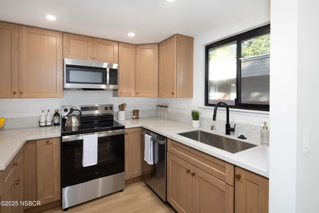 a kitchen with stainless steel appliances granite countertop a sink a stove and cabinets
