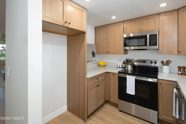 a kitchen with stainless steel appliances a stove microwave and sink