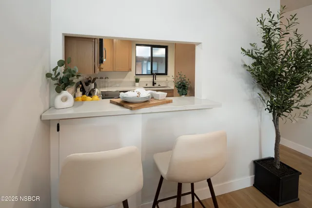 a room with a table chairs and a potted plant