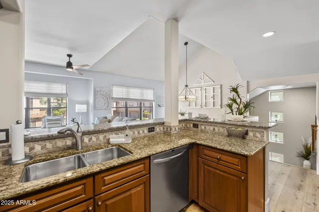 a kitchen with stainless steel appliances granite countertop a sink a stove and cabinets