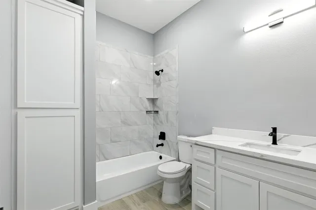 an empty room with wooden floor cabinet and windows