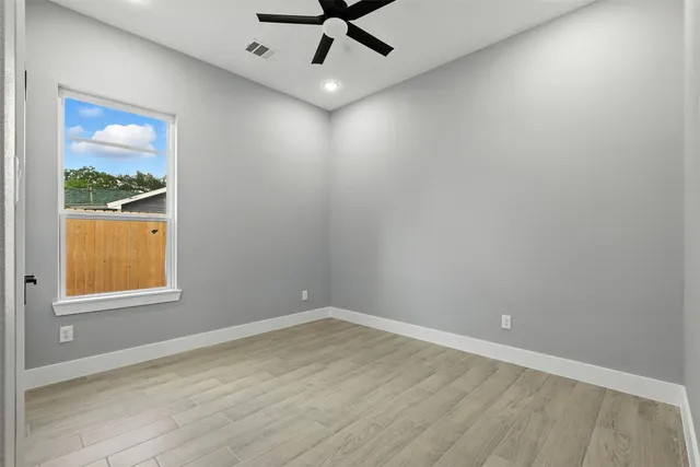 a view of an empty room with cabinet and a window