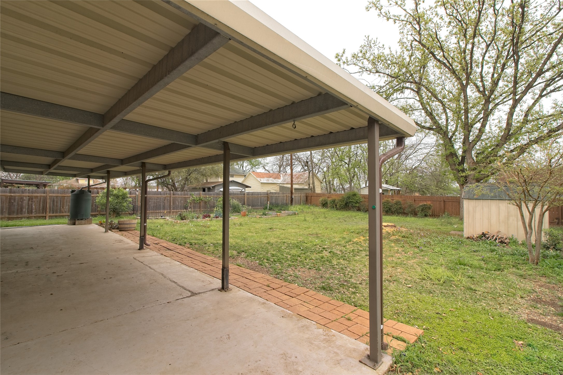 1102 Fowzer Street Taylor, TX 76574 - Photo 24 of 27 Fenced backyard with a patio and a storage unit