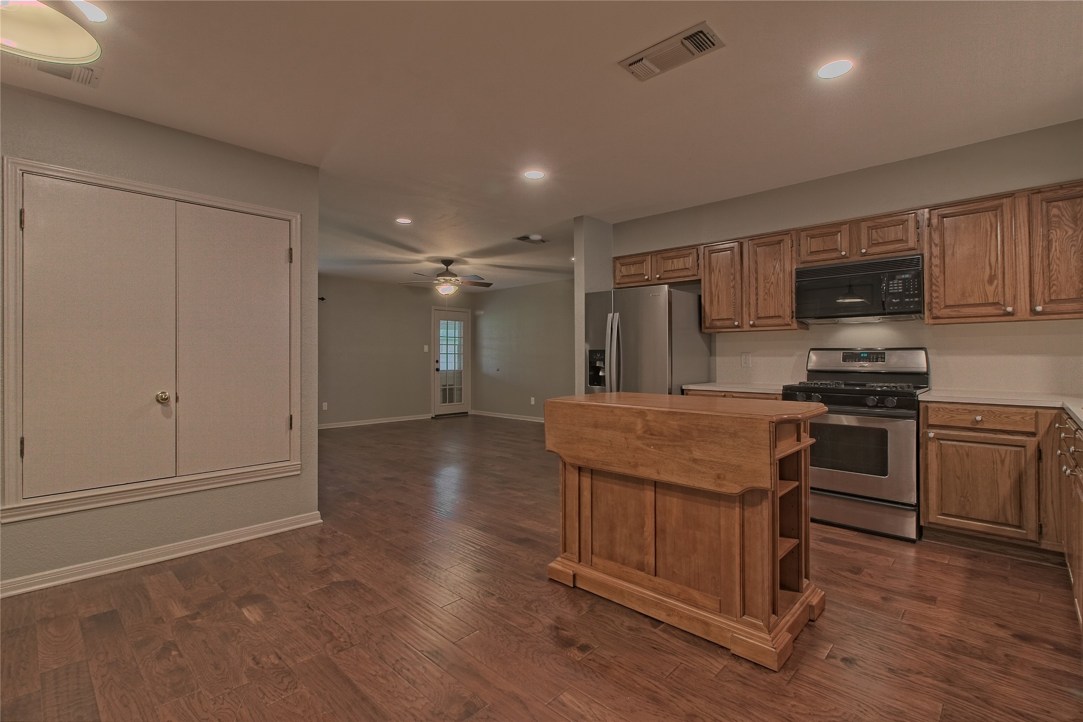 1102 Fowzer Street Taylor, TX 76574 - Photo 10 of 27 Kitchen featuring light countertops, stainless steel appliances, a kitchen island, dark wood finished floors, and a ceiling fan