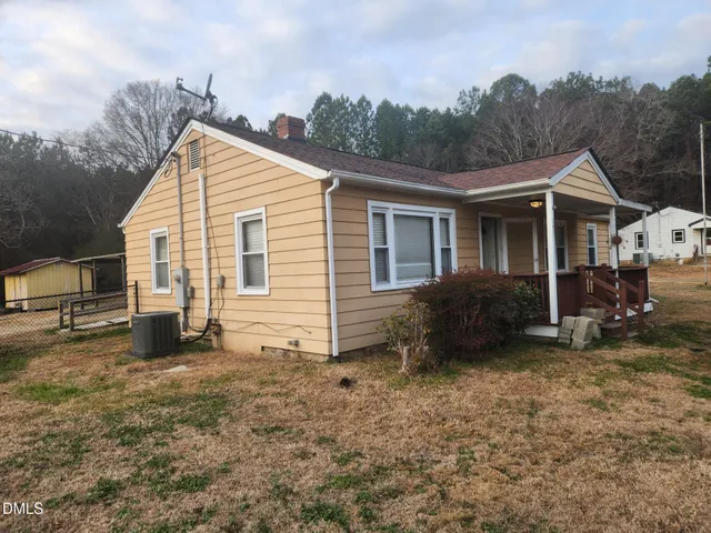 a view of a house with a yard and lawn chairs
