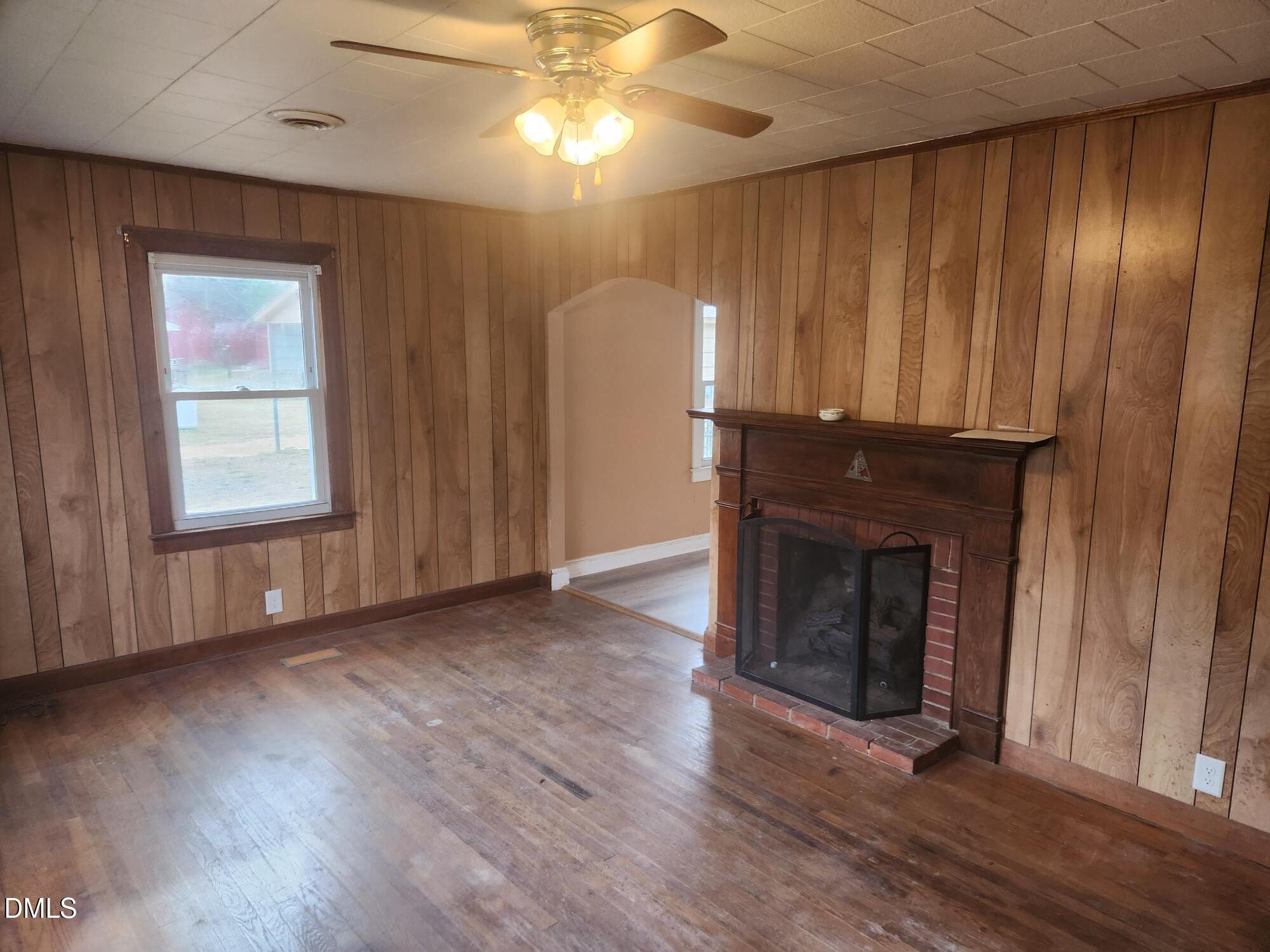 83 Wimberly Road Moncure, NC 27559 - Photo 8 of 17 an empty room with wooden floor fireplace and windows