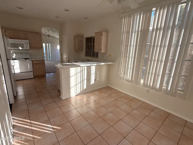 a view of a kitchen with kitchen island granite countertop stainless steel appliances counter space and a window